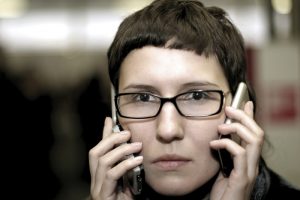 woman trying to multitask with two phones