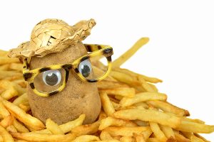 potato with straw hat and glasses in a pile of golden french fries. Use uniqueness for team success.